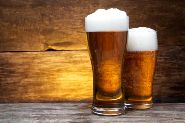 Дві склянки пива над вінтажним деревом — стокове фото