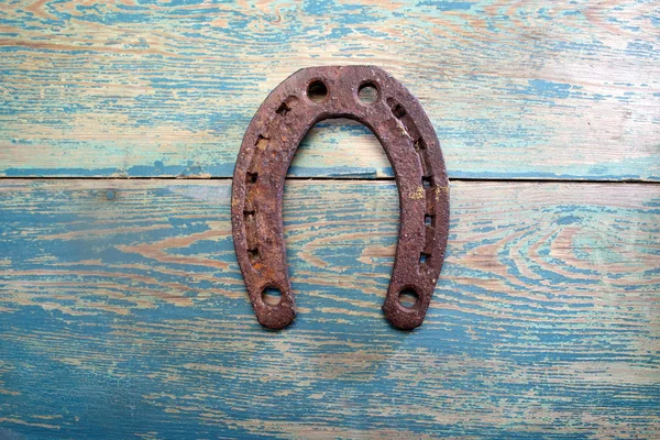 Старая железная ржавая металлическая подкова на выветренной древесине — стоковое фото