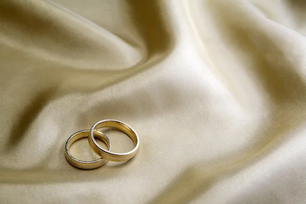Anillos de boda en seda dorada — Foto de Stock
