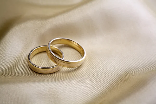 Wedding rings  on golden silk — Stock Photo, Image