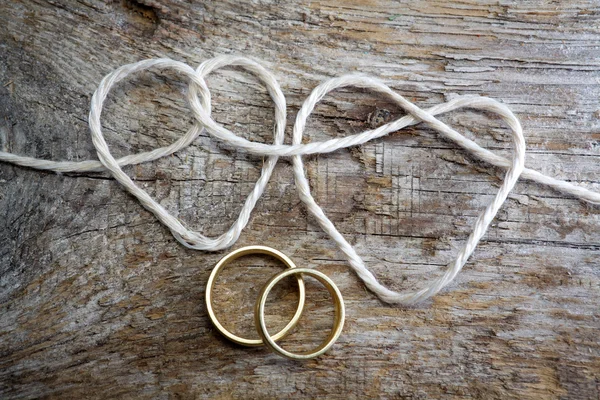 İp ve bir çift altın yüzük çift kalp şeklinde — Stok fotoğraf
