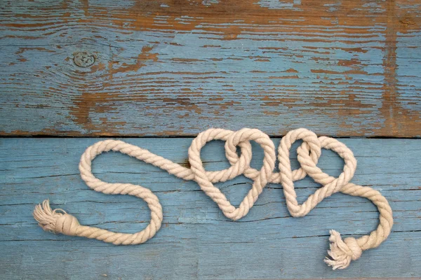 Laisse la corde en forme de coeur sur le bois — Photo