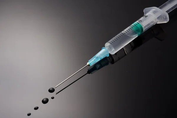 Medical syringe with solution drop — Stock Photo, Image