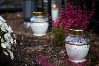 Huzurlu bir bahçe sahnesi. İçinde mumlar ve canlı çiçekler var. Huzurlu ve yansıtıcı bir ortam yaratıyor..