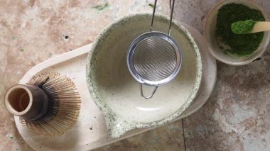 Travertini arka planında geleneksel aletlerle serin bir kibrit çay seti..