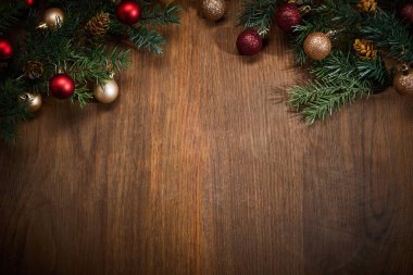 Ahşap bir yüzeyde şenlikli çam dalları ve mücevherler..