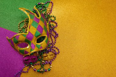 Mardi Gras maskesi ve renkli boncuklar ışıltılı bir arka planda karnaval şenliklerini kutluyor.