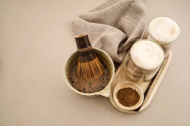 Chasen ve kavrulmuş yeşil çay tozuyla servis edilen Hojicha latte içecekler.