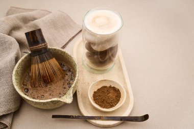 Çay tozu, bambu çırpısı ve köpüklü sütle hojicha latte hazırlıyorum.