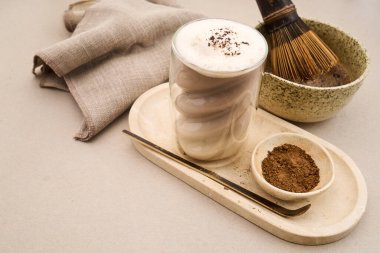 Kavrulmuş yeşil çay tozu ve bambu çırpıyla servis edilen Hojicha latte.