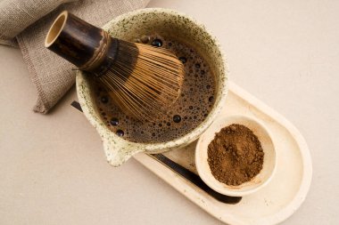 Hojicha tozu sıcak bir içeceğe karışıyor, servis için hazır.