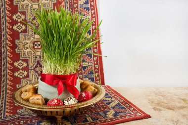 Geleneksel İran halısı üzerinde Sabzeh, boya yumurta ve baklava ile Nowruz haft-sin masası