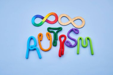 Gökkuşağı ve ahşap sonsuzluk sembolleriyle otizm oluşturan renkli duyusal oyuncaklar