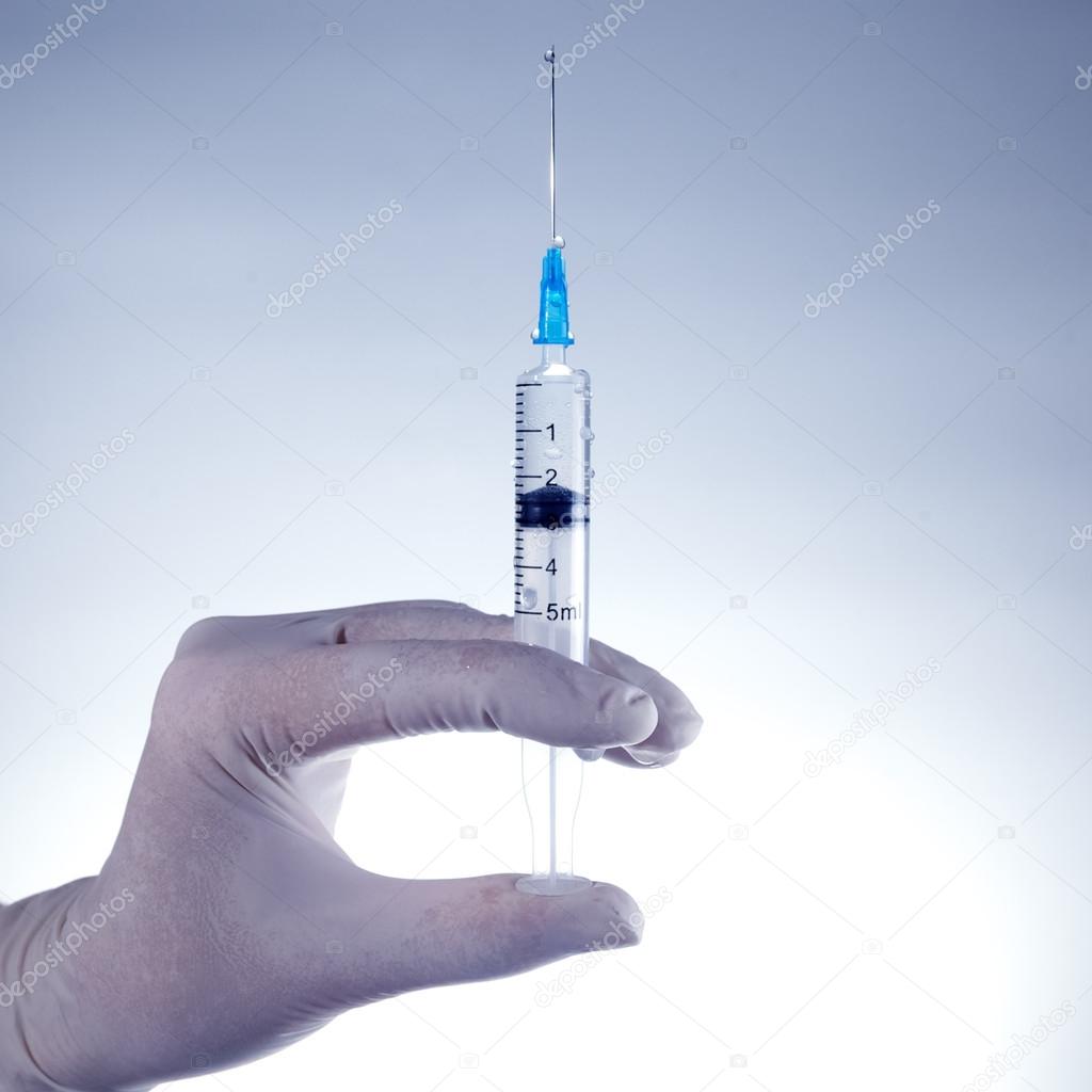 Hands of the doctors filling a syringe