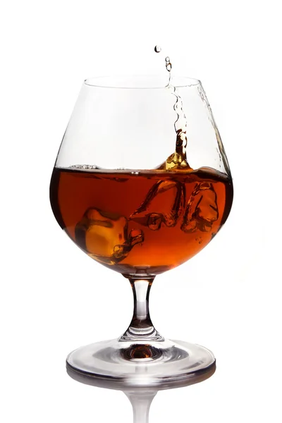 Splash of cognac in glass Stock Photo