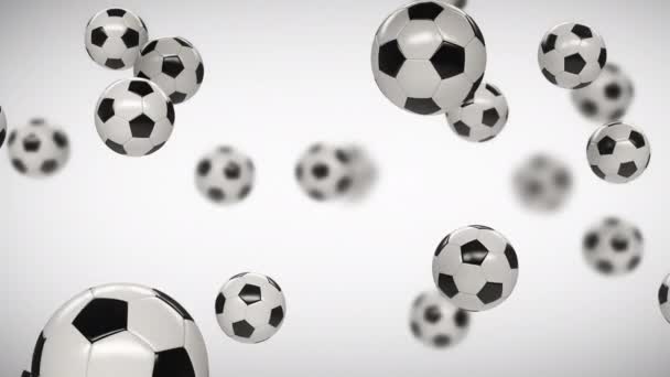 Soccer balls falling from top to bottom on a white and green background with depth of field. — Stock Video