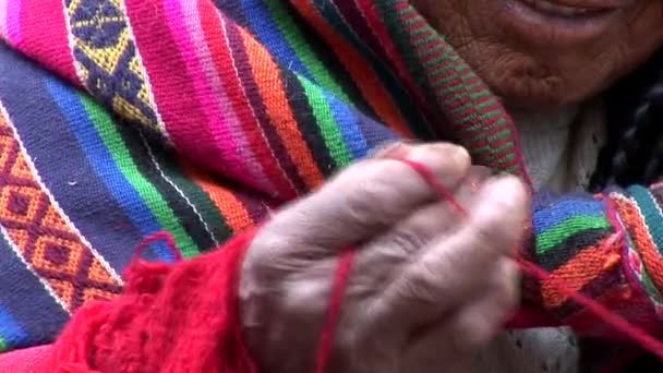 Woman in a street in Cusco spinning wool — Stock Video