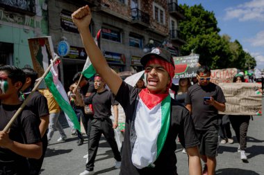 Puebla, Meksika, 7 Ekim 2025: Genç öğrenci Filistin 'le dayanışma göstererek Puebla, Meksika' da ateşli bir protesto için yumruğunu kaldırdı.
