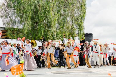 Puebla, Meksika 28 Eylül 2025: Büyük bir açık hava kültürel kutlaması sırasında renkli geleneksel kostümlü büyük bir Meksikalı dansçı grubu.