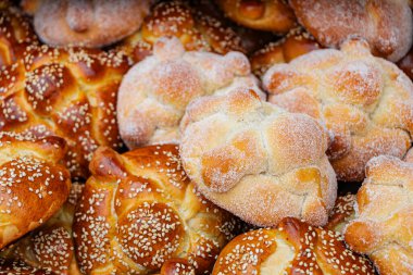 Pan de Muerto 'nun yakın çekimi, geleneksel bir Meksika tatlısıdır. Şekerli ve susam çeşitleri arasındaki zıtlığı gösterir..