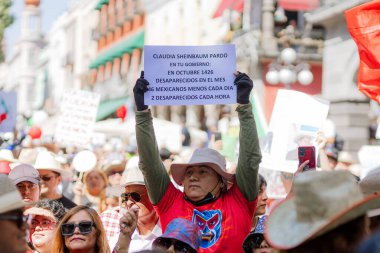 Puebla, Meksika; 11-15-25: Protestocu, Puebla 'daki büyük bir yürüyüş sırasında Claudia Sheinbaum hükümetini kınayarak ortadan kaybolan istatistiklerle ilgili bir pankart kaldırdı