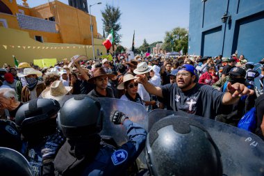 Puebla, Mxico; 11-15-25: Puebla, Meksika 'da bir koloni caddesinde şapka ve Meksika bayrağı taşıyan büyük bir protestocu kalabalığının yüksek açılı görüntüsü.