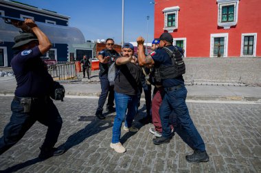 Puebla, Mxico; 11-15-25: Puebla caddesinde şiddetli fiziksel kavga. Siyasi gösteri sırasında çok sayıda polis memuru bir protestocuyu gözaltına almak için mücadele etti.