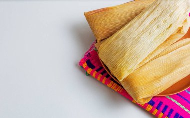 Bir kil plaka üzerinde Meksika tamalelerinin yatay bileşimi, beyaz arka planda izole edilmiş ve reklam için kopya alanı var..