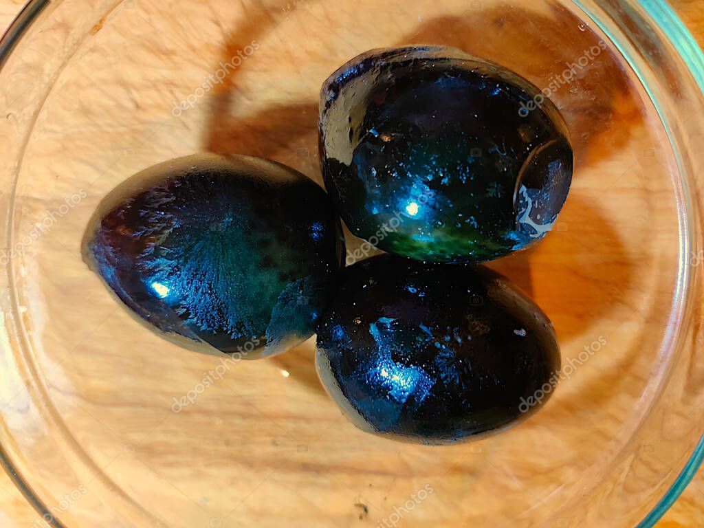 Three chinese century eggs on the cutting board.
