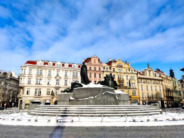 Prag 'ın Eski Şehir Meydanı' nın tarihi binaları, ortasında Jan Hus heykeli olan dondurucu kış boyunca. Koronavirüs salgını yüzünden sokaklar neredeyse boş. Mavi gökyüzünde güzel bulutlar var.