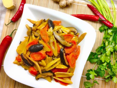 Bambu filizlerinden, şitake mantarından ve havuçtan yapılmış Asya usulü bir yemek. Ayrıca tabağın etrafında kırmızı biber, zencefil ve kişniş de var.,