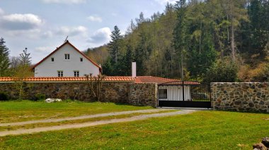 Divoka Sarka Vadisi 'ndeki güzel ev, Prag' daki doğal rezerv. Nokta ormanla çevrili. Hava sıcak ve küçük bulutlarla güzel. Ayrıca ön tarafta taş duvar ve metal kapı var..
