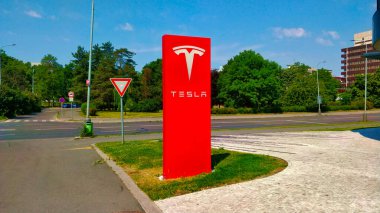 Prag, Çek Cumhuriyeti - 19 Haziran 2021: Tesla imzalı büyük kırmızı sütun Tesla araba satan bir araba satıcısını işaret ediyor. Prag, Çek Cumhuriyeti 'nde lüks arabalar satan araba satıcısının önünde..