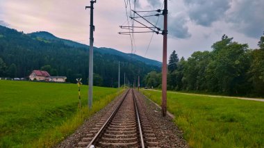 Avusturya Alpleri 'nin Montan bölgesinden geçen düz demiryolu hattı. Pist elektrikli ve pistin her iki tarafında da çimen var..