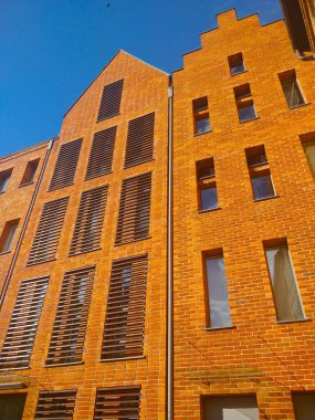 Gdansk, Polonya - 26 Ağustos 2021: Şehir merkezindeki Gdansk rıhtımındaki eski tarz modern bina. Bina kırmızı tuğlalardan yapılmıştır..
