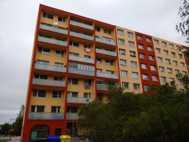 Kladno, Çek Cumhuriyeti - 19 Eylül 2021: Bulutlu bir günde tuhaf balkon kompozisyonu olan bej ve kırmızı yeniden inşa edilmiş apartman blokları.