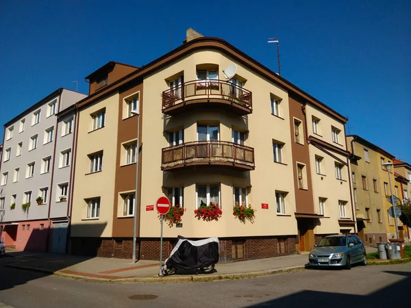 Ceske Budejovice, Çek Cumhuriyeti - 5 Eylül 2021: Bodrumunda balkon ve kırmızı çiçekler bulunan bej köşeli apartman.