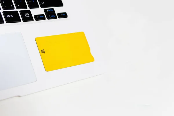 Yellow credit card on a laptop. Online shopping concept. E-commerce.