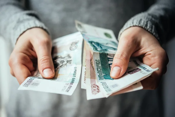 Mãos segurando notas rublo russo — Fotografia de Stock