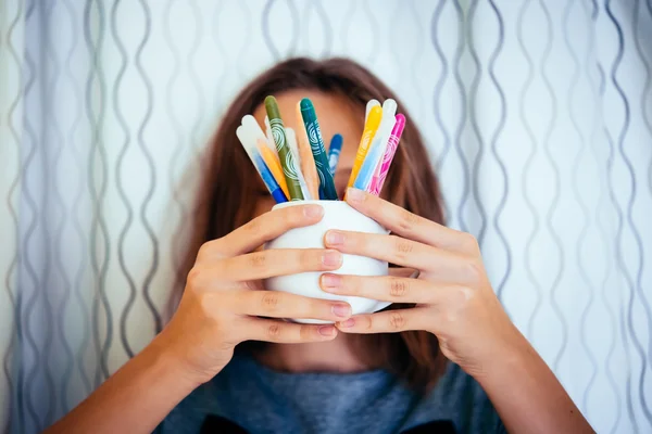 Chica sostiene un vaso con lápices —  Fotos de Stock