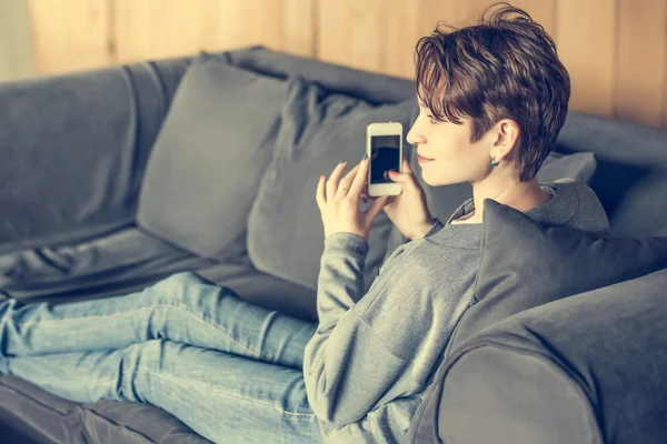 Mujer sentada con teléfono inteligente —  Fotos de Stock