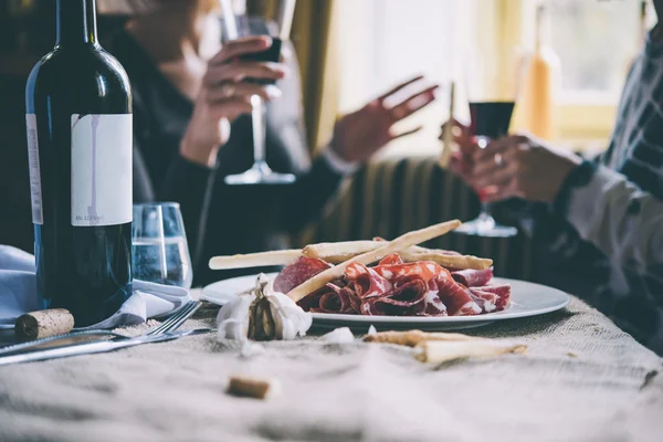 Restaurant or bar table with plate of appetizers and wine