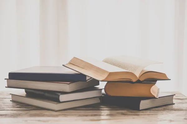 Pilha de livros sobre mesa de madeira — Fotografia de Stock