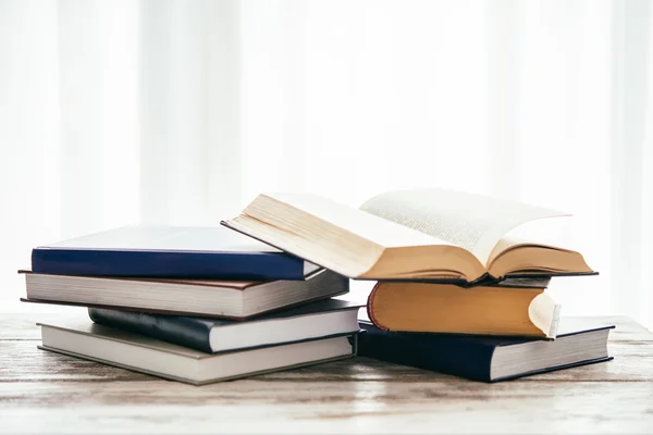 Pilha de livros sobre mesa de madeira — Fotografia de Stock