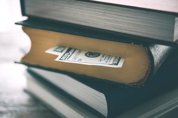 Pile of books and us dollar bill — Stock Photo, Image