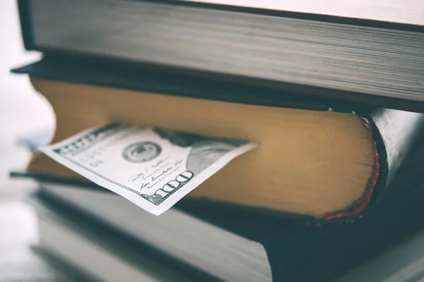 Stapel boeken en ons dollarbiljet — Stockfoto