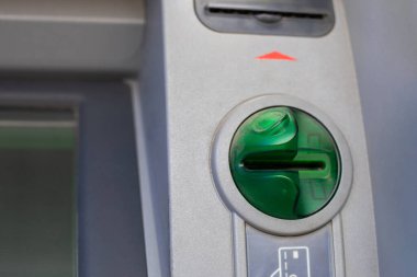 Yakın çekim ATM kartı okuyucusu, dolandırıcılıktan korunan yeşil kart okuyucusu. Banka hesabından para çekmek için otomatik bir makinenin yatay fotoğrafı