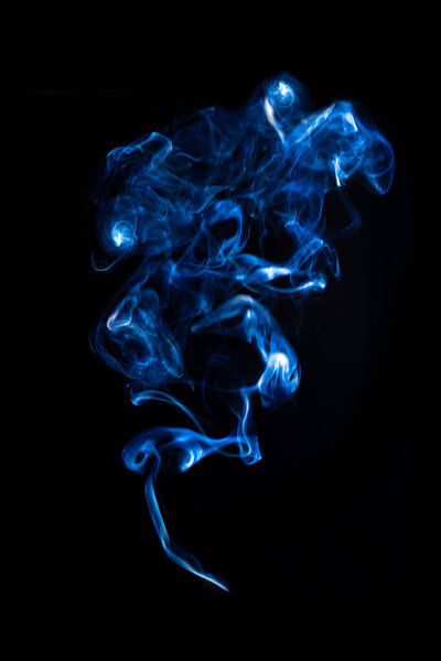 Jet of blue smoke isolated on black background. Swirls of smoke from vape or cigarette, vertical pattern for design