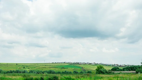乡郊居民点村 山上绿油油的草地 美丽的乡村风景 绿树成荫 天空多云 — 图库照片