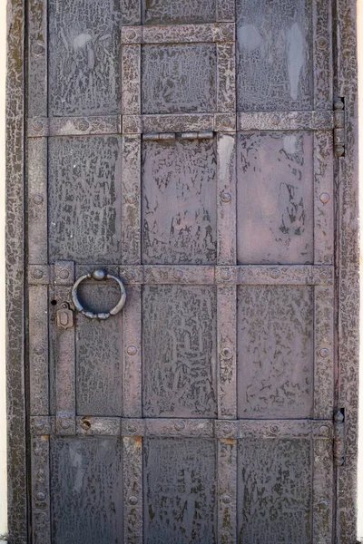 幾何学的な装飾が施された古い金属製のドア ヒンジ付きの表示窓と大きなリング 亀裂や腐食と古い金属表面のテクスチャ — ストック写真